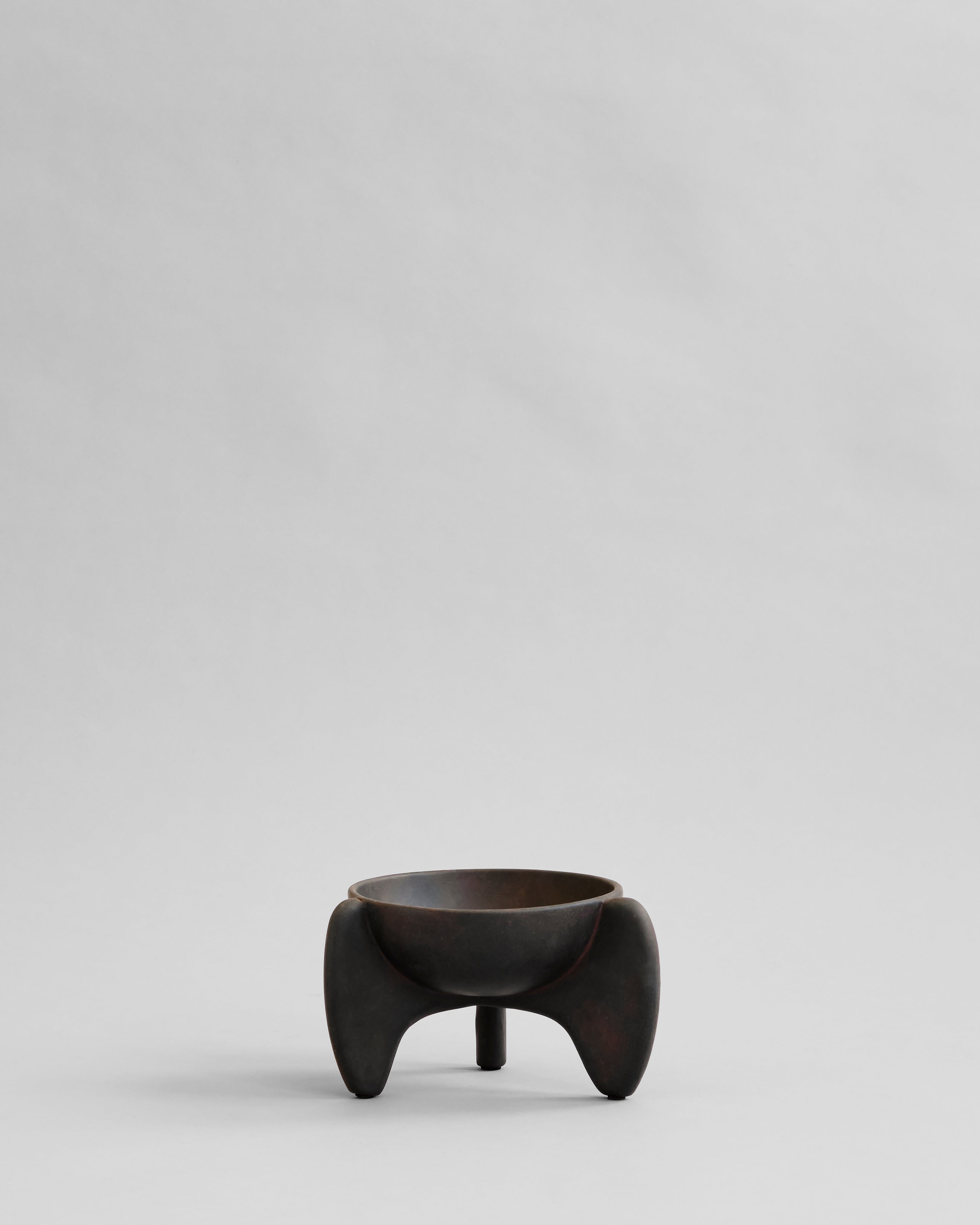 Black ceramic bowl with unique design on a light gray background