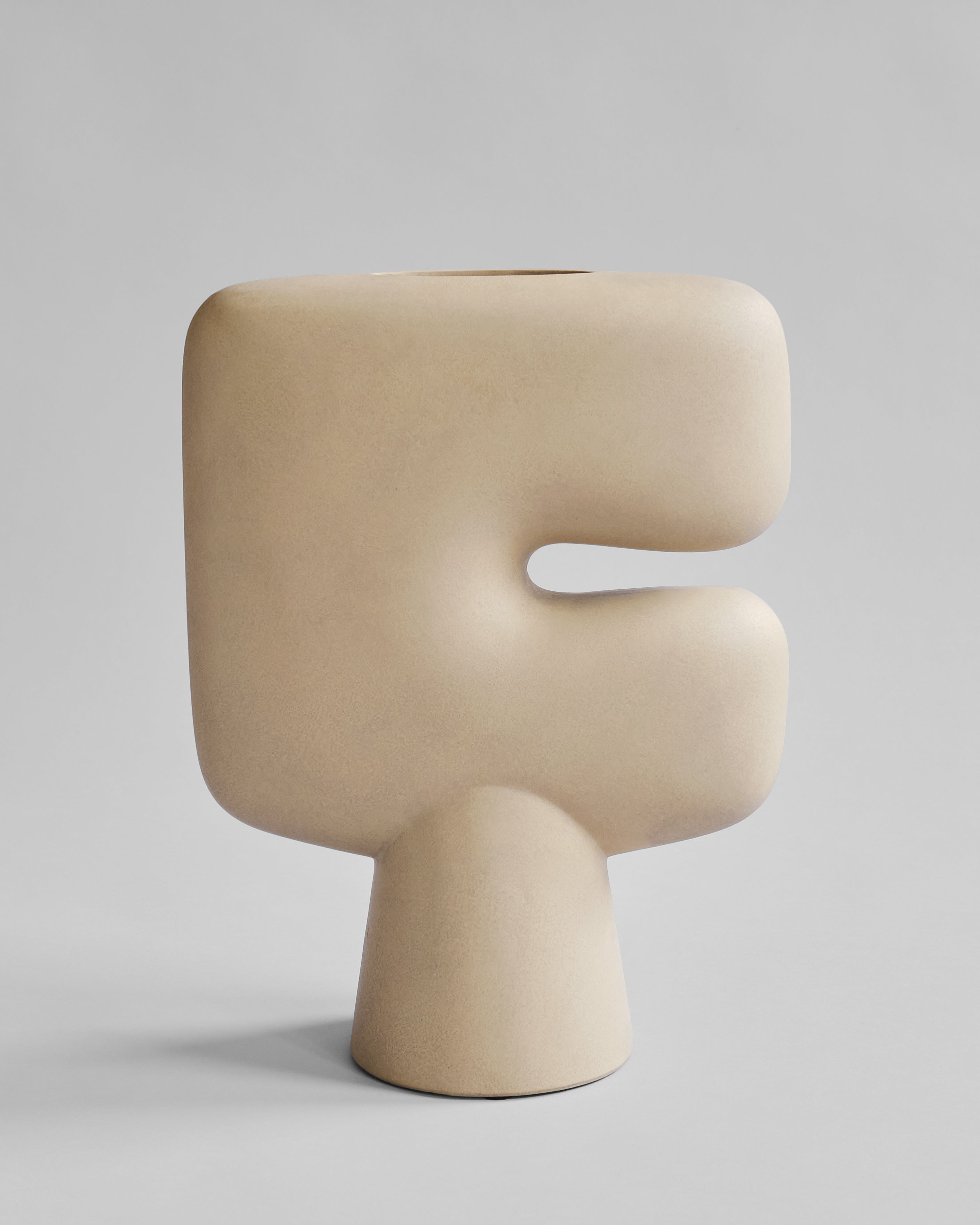 Beige letter 'F' shaped vase on a light gray background