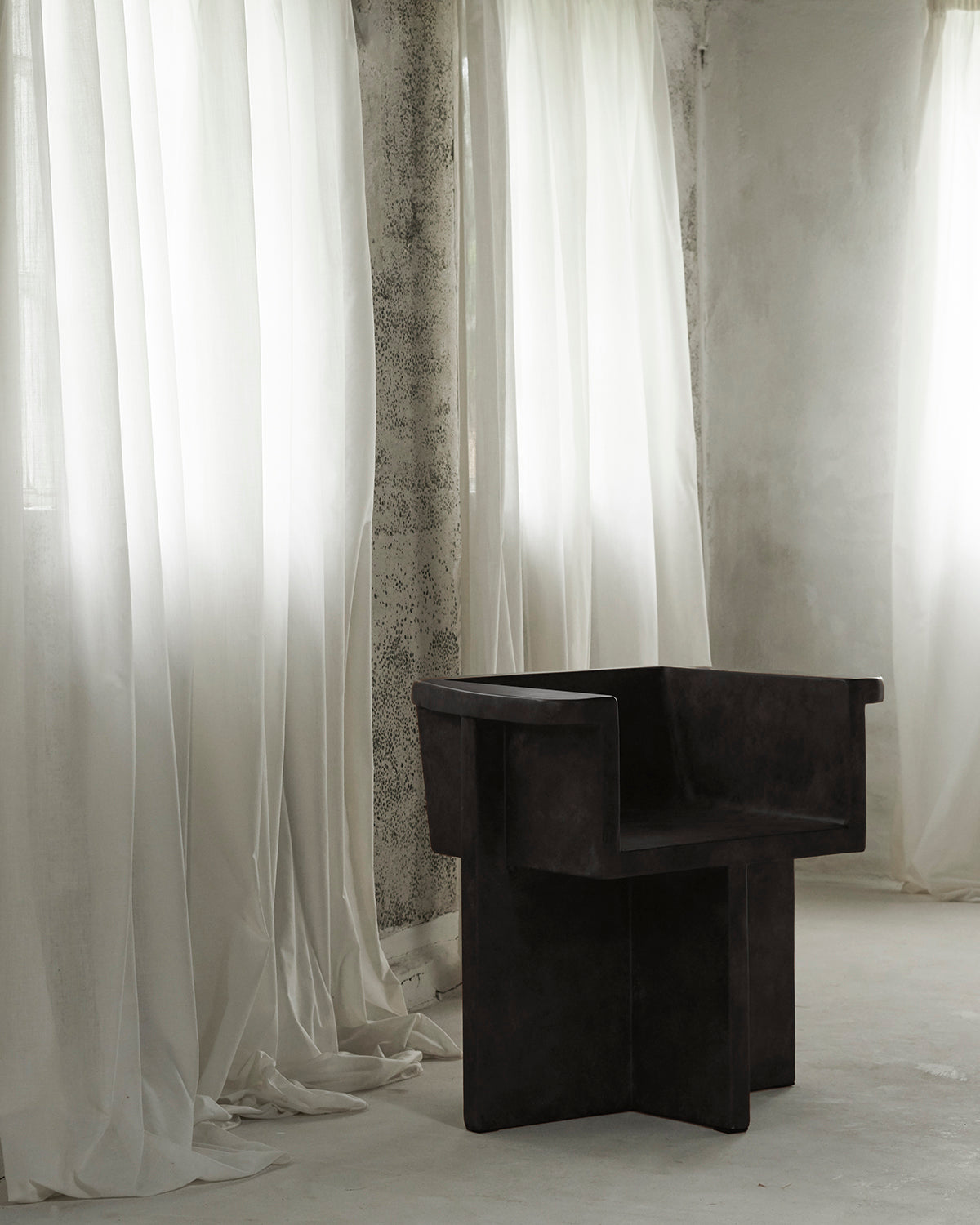 Modern black dining chair in front of white curtains. 101 Copenhagen Brutus Dining Chair, Curated by Numa Home