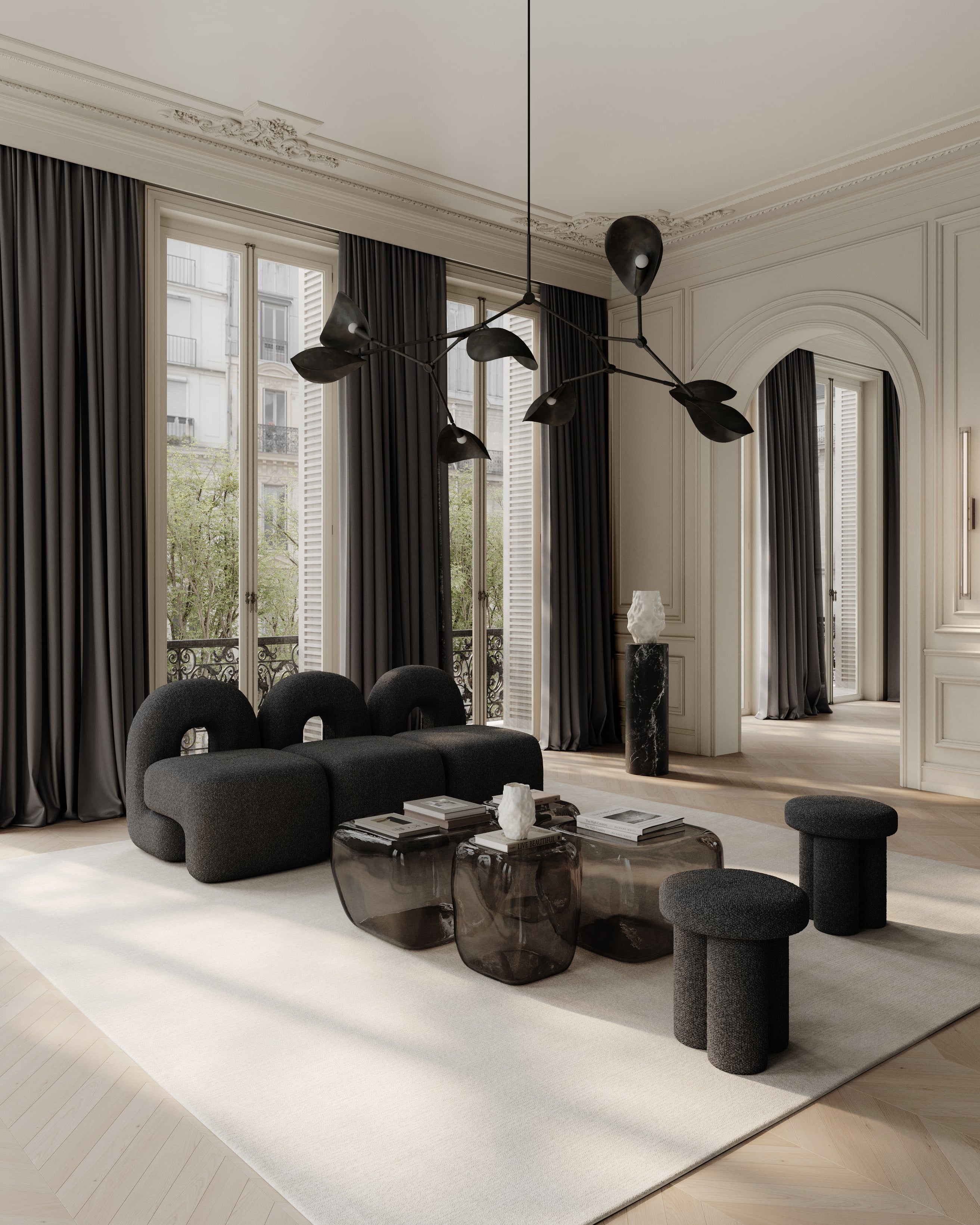 Modern living room with black furniture and large windows. Katachi Vase, Medio by 101 Copenhagen. Sculptural vase inspired by Japanese “shape”, available in High Glaze Birch ceramic and Clear or Smoked Forest mouth-blown glass. Fully waterproof – curated by Numa Home.
