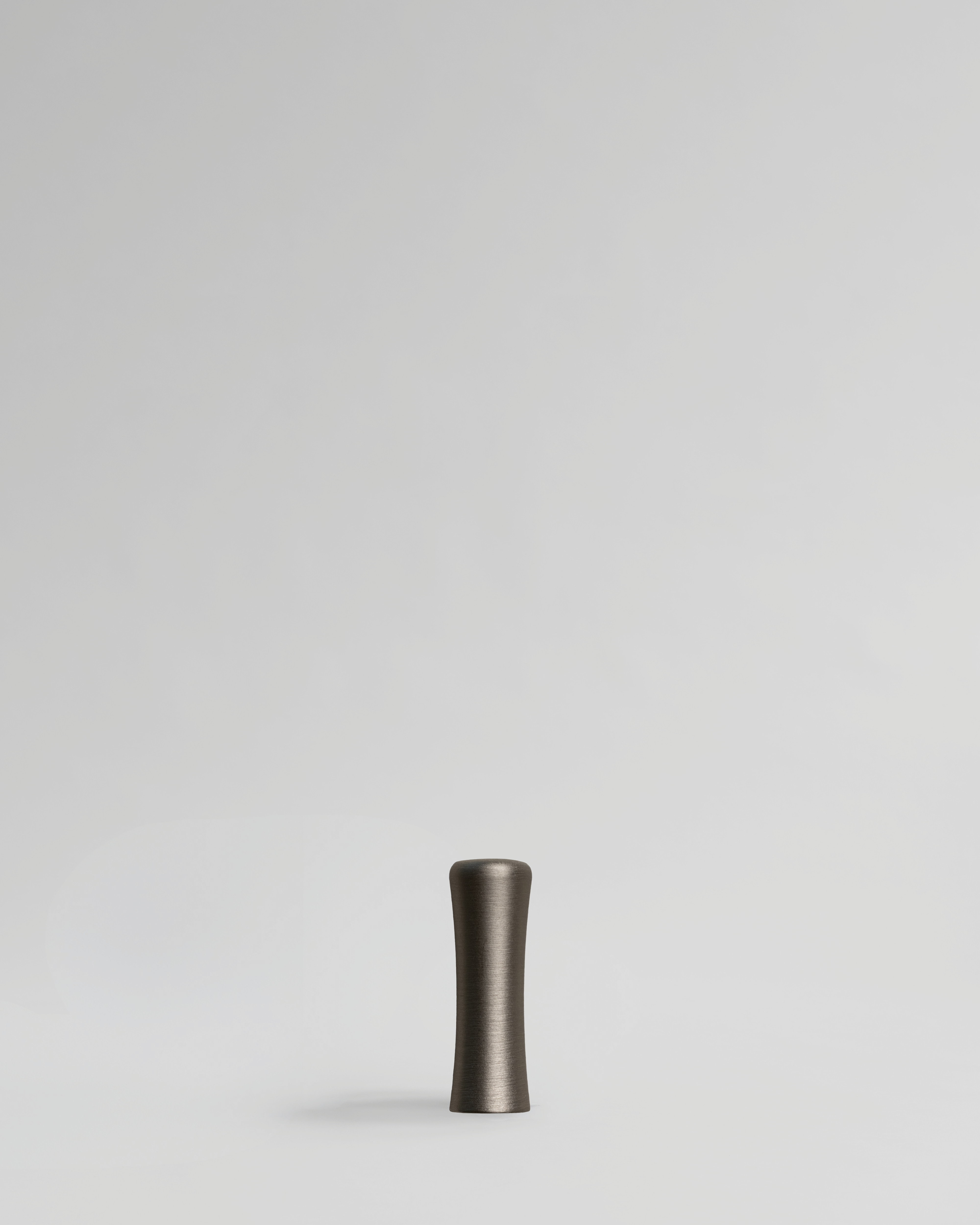 Brushed nickel cabinet handle pull on light gray background. Brass cabinet handle designed by Stef Claes, created by Sumum, curated by Numa Home.