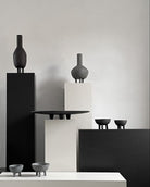 Modern black and gray ceramic vases and bowls on a neutral background