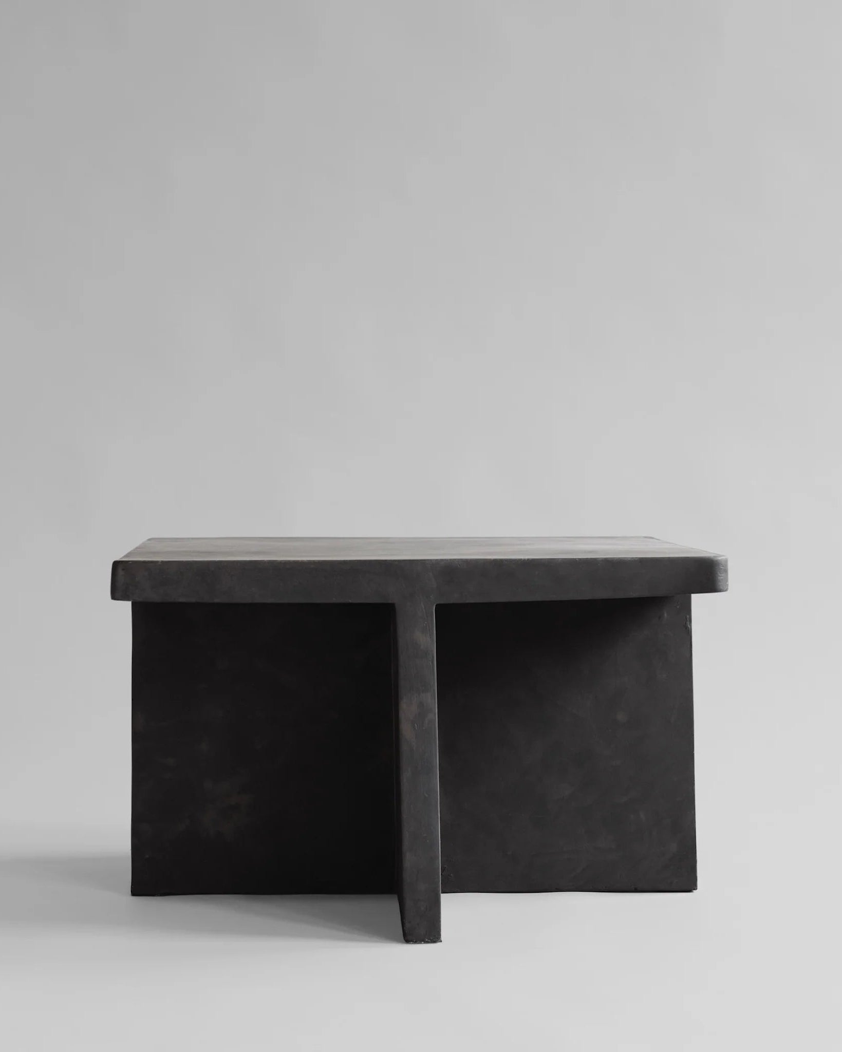 Black stone bench on a light gray background. Brutus Coffee Table by 101 Copenhagen curated by Numa Home
