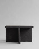 Black stone bench on a light gray background. Brutus Coffee Table by 101 Copenhagen curated by Numa Home