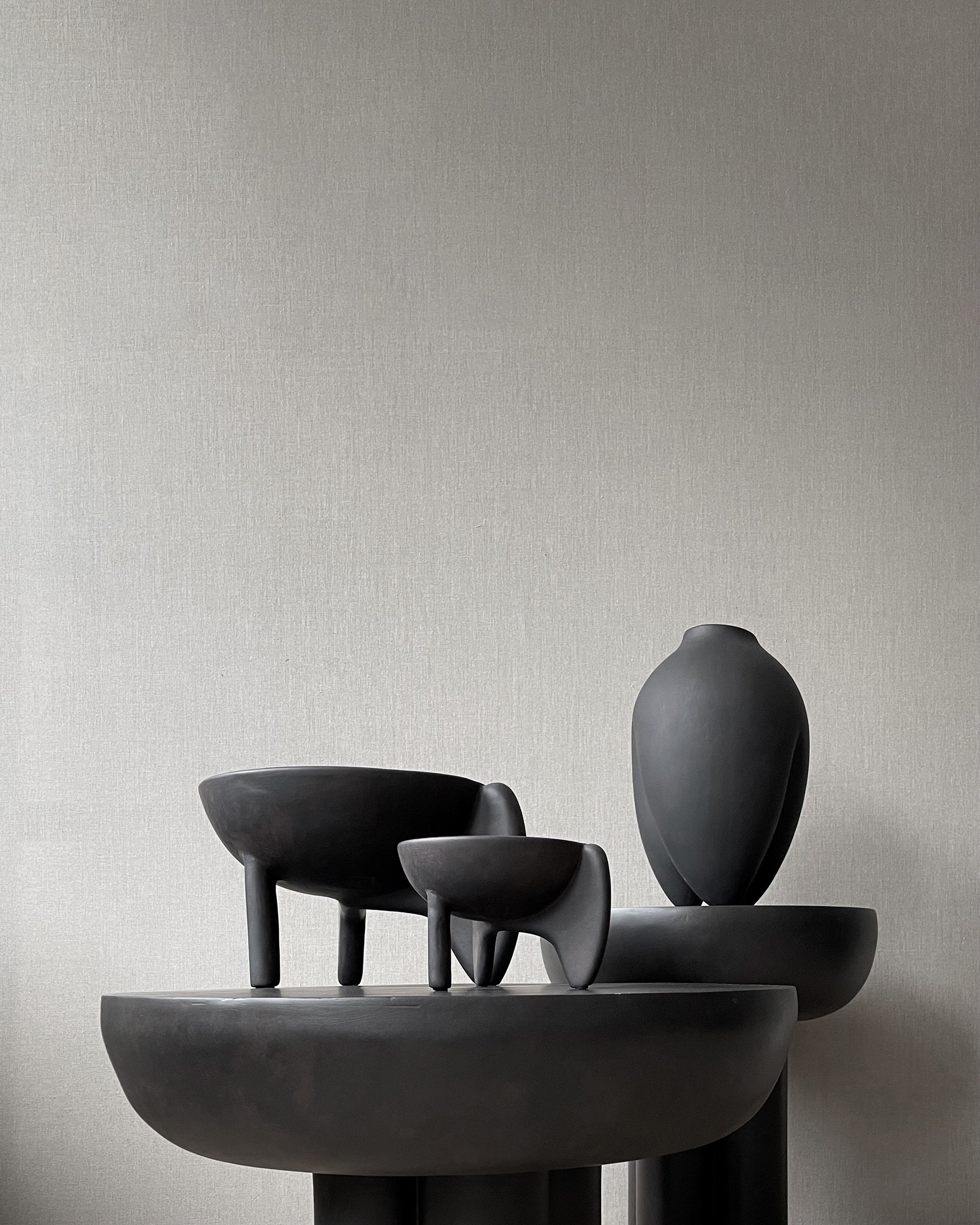 Set of black ceramic sculptures on a neutral background