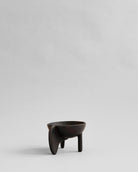 Black ceramic cup with a handle on a light gray background