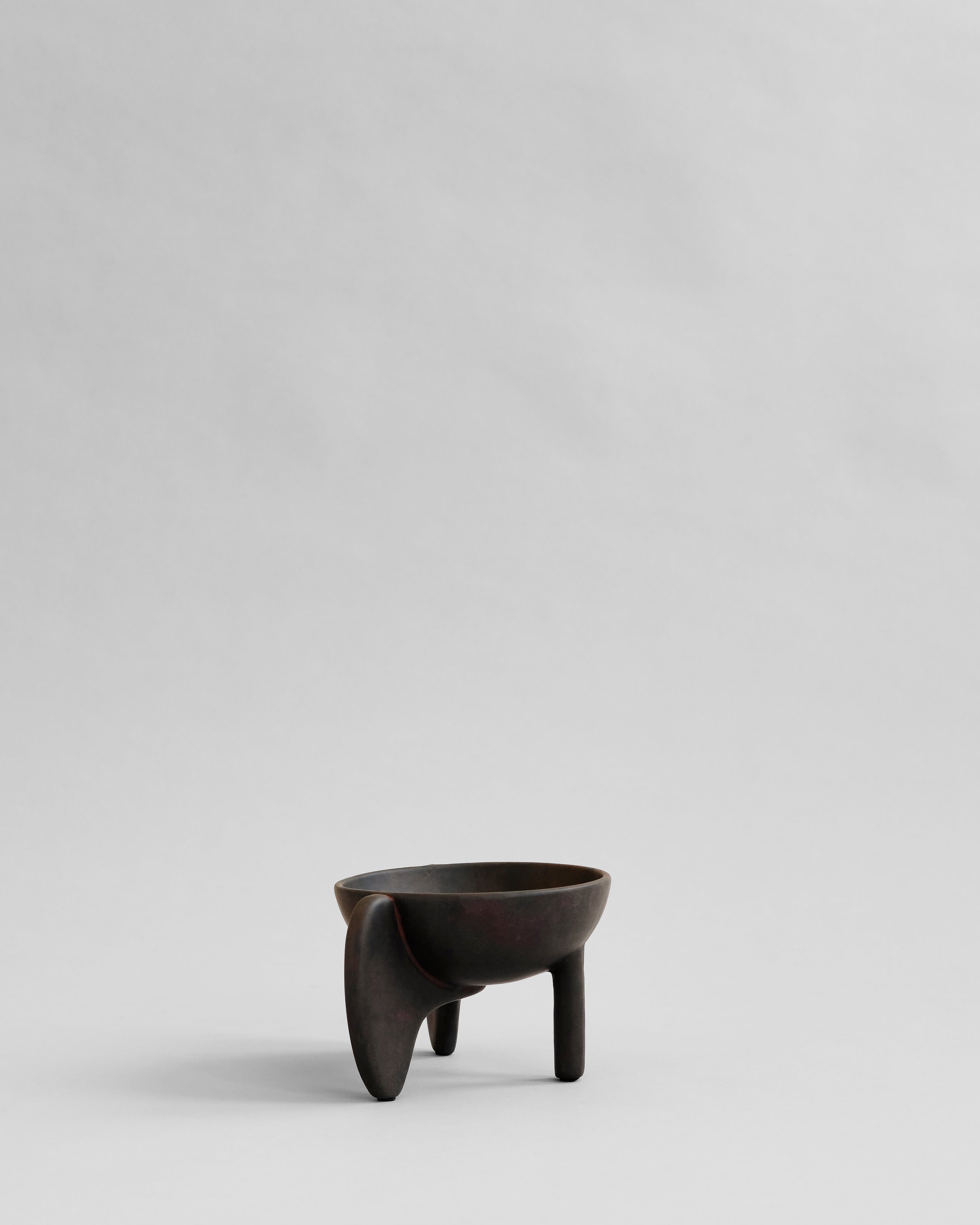 Black ceramic cup with a handle on a light gray background