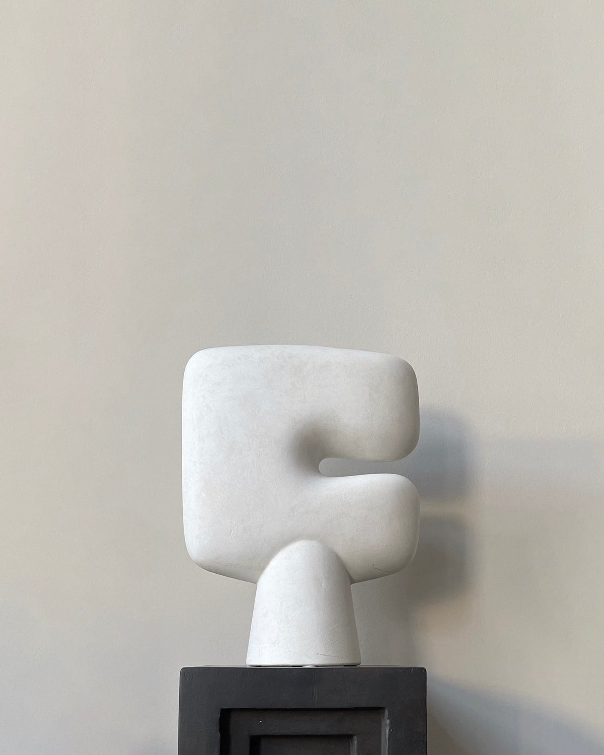 Abstract white sculpture on a gray background. Tribal sculprural vase