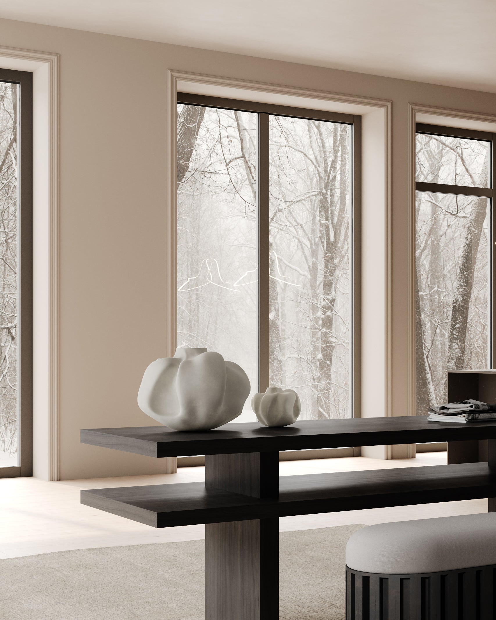 Modern interior with a black dining table and white sculptures in front of large windows showing trees.