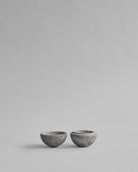 Two small gray ceramic bowls on a light gray background