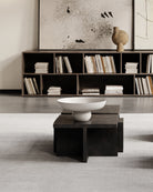 Modern living room with a bookshelf, coffee table, and decorative items. Brutus coffee table by 101 CPH curated by Numa Home