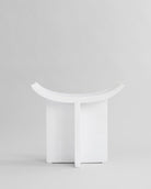 White stool with curved design on a light gray background