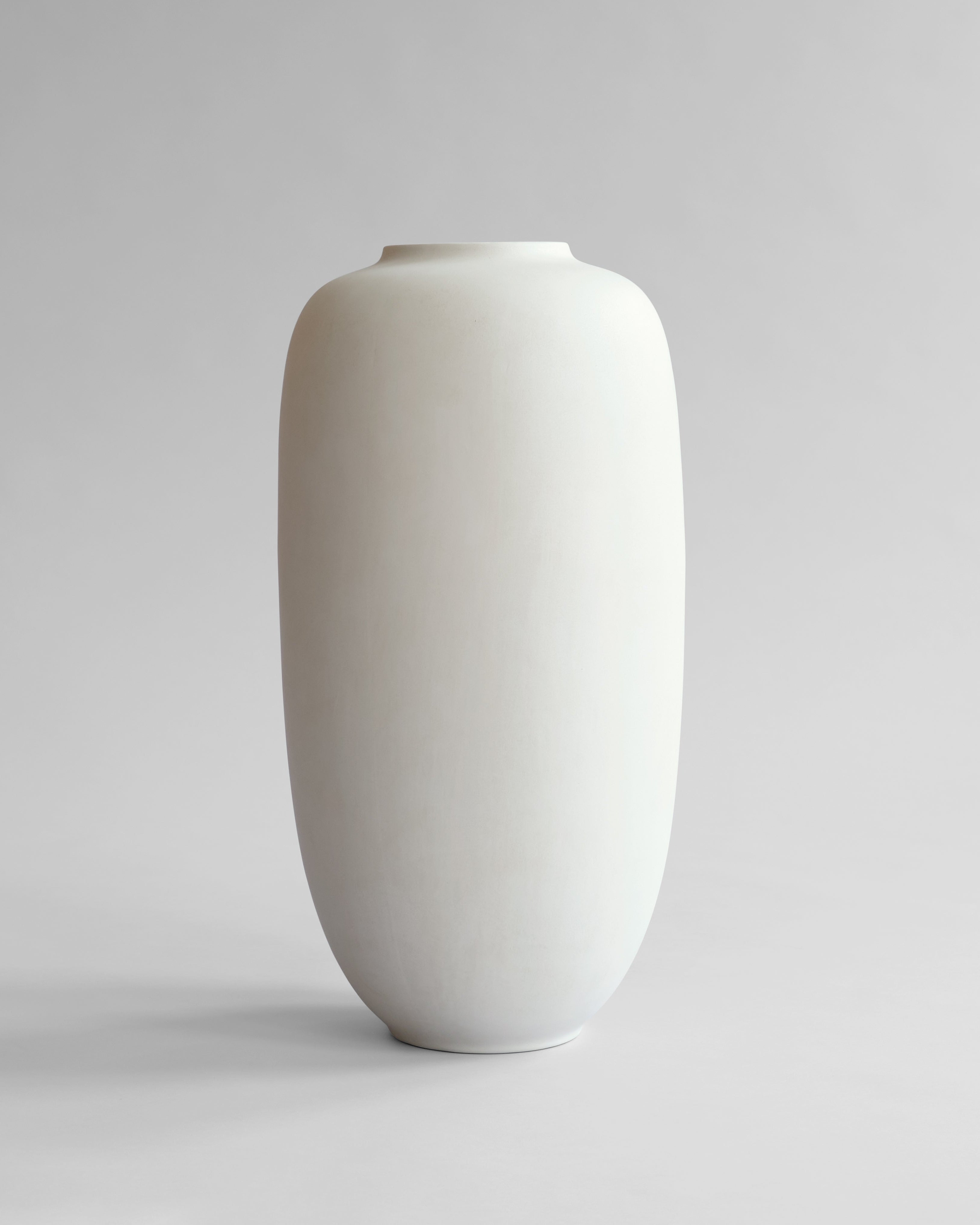 White ceramic vase on a light gray background. Sunao Vase Slim, Hexa by 101 Copenhagen, curated by Numa Home