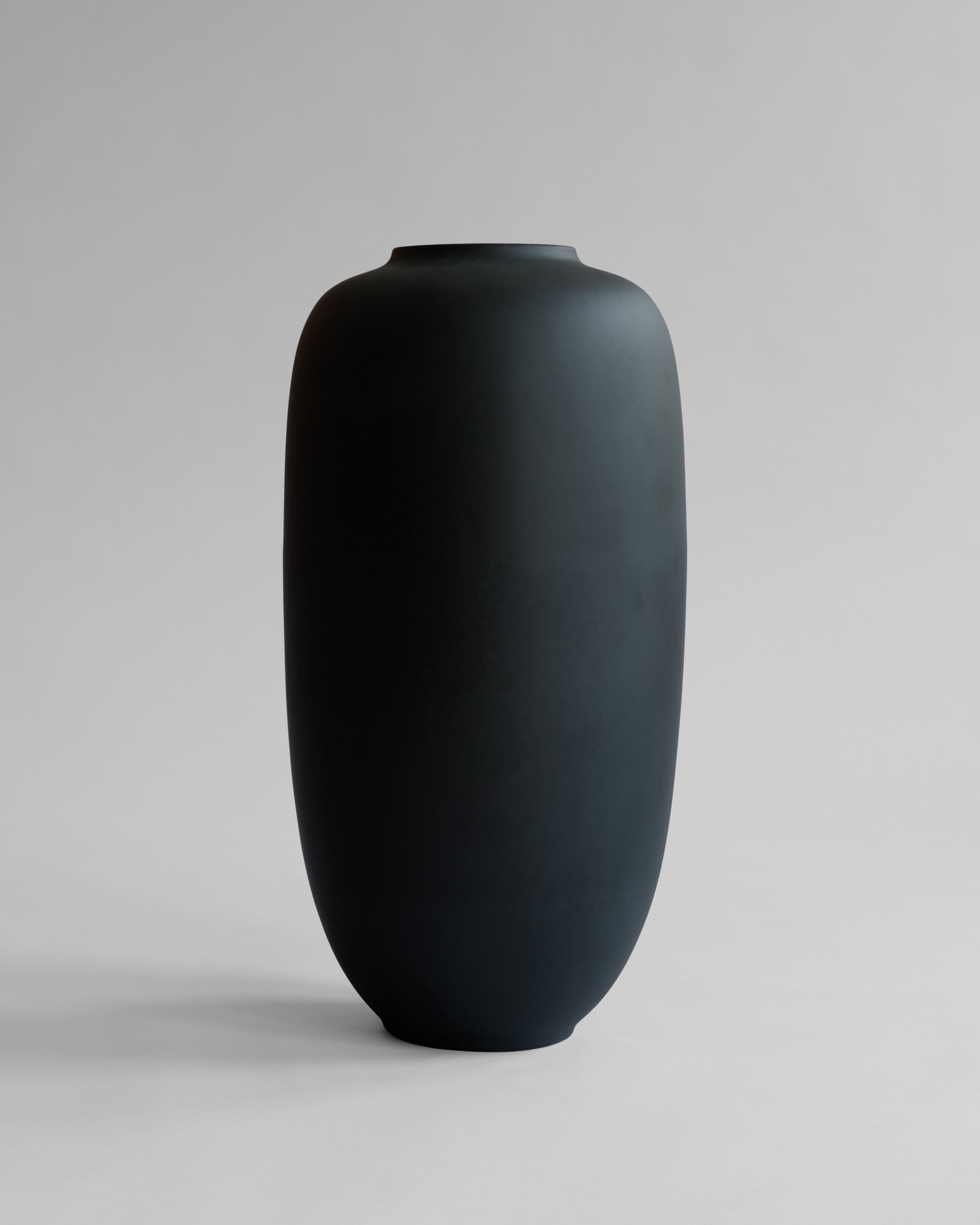 Black vase on a gray background. Sunao Vase Slim, Hexa by 101 Copenhagen curated by Numa Home