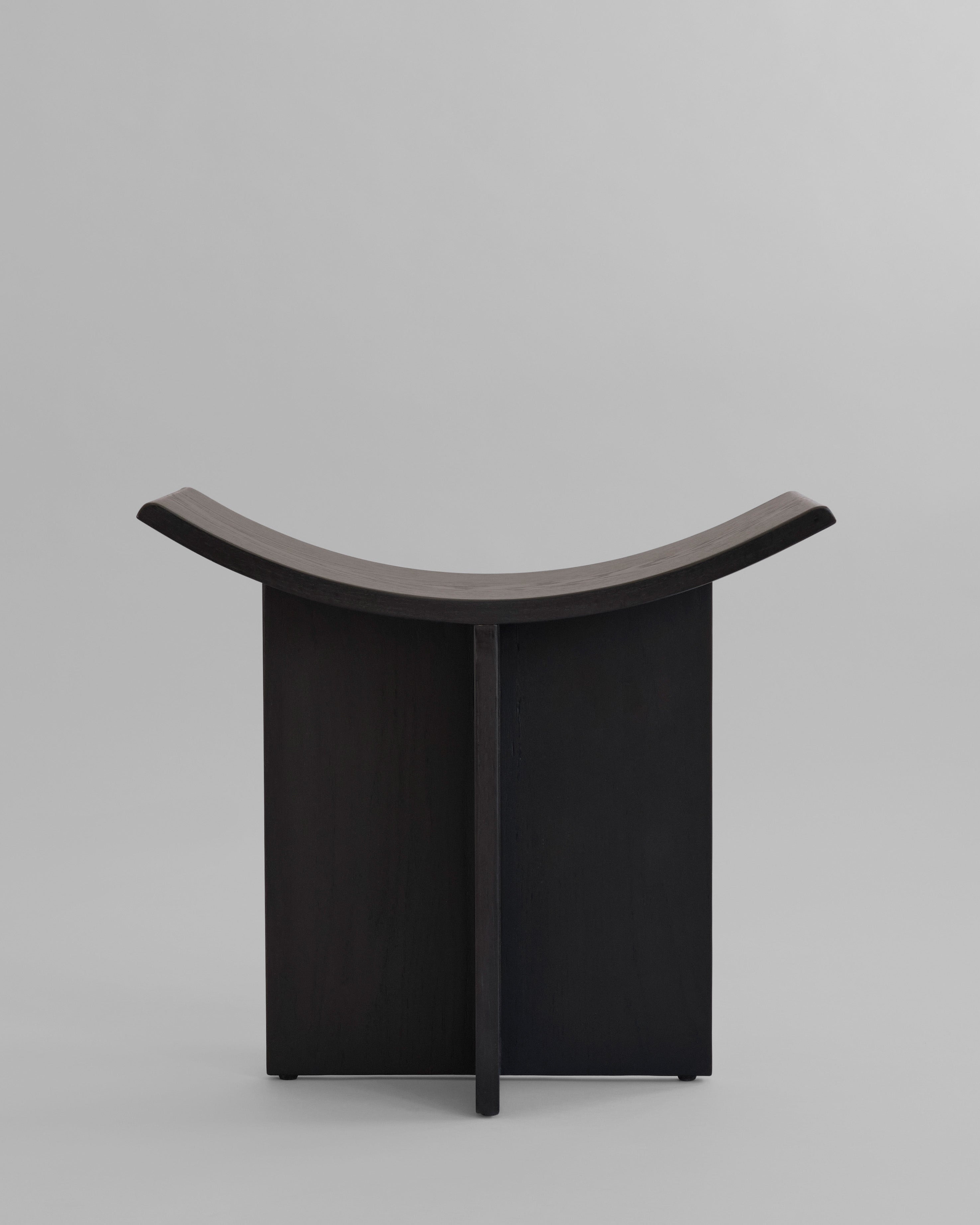 Black curved oak stool on a light gray background