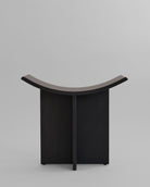 Black curved oak stool on a light gray background