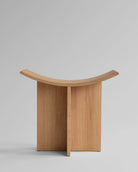 Oak 101 CPH Brutus stool with a curved design on a gray background