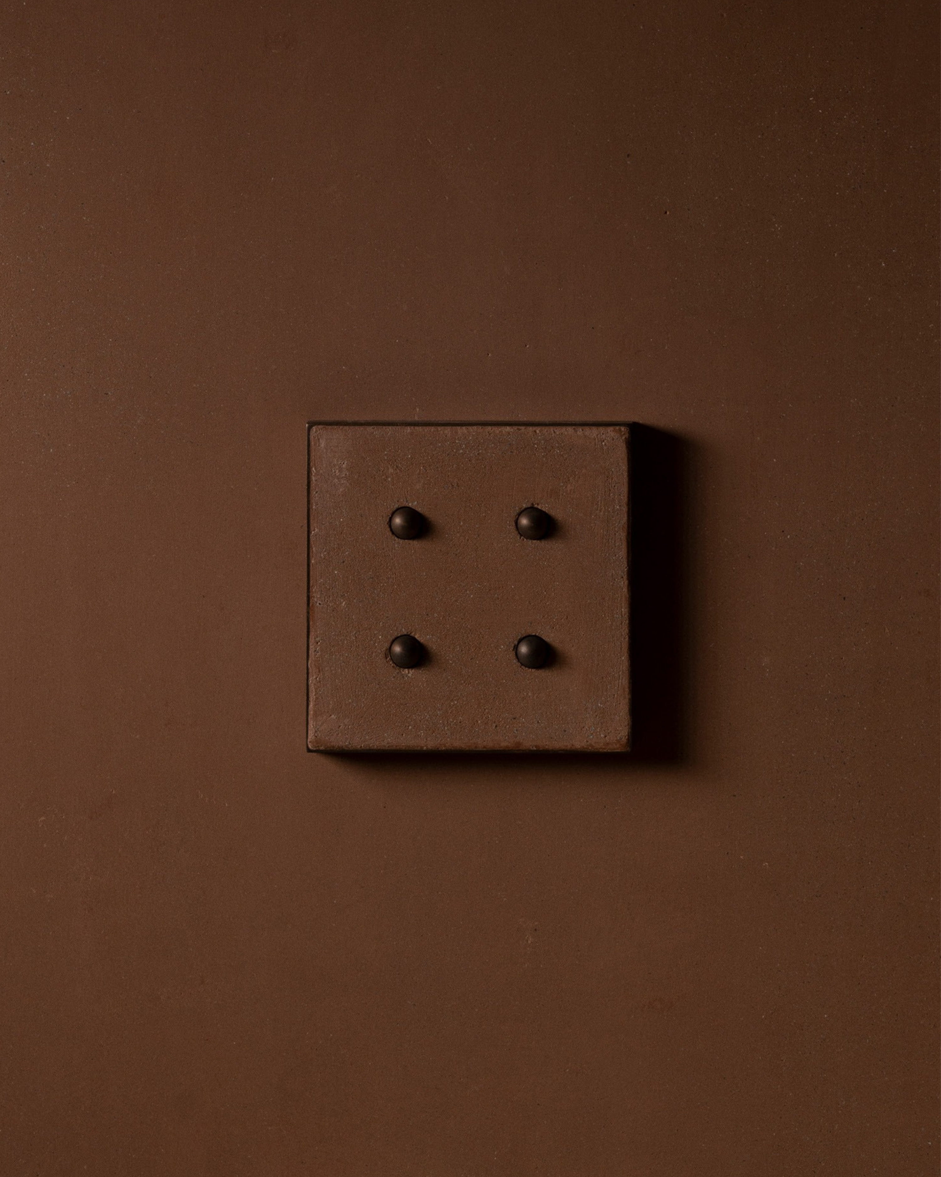 Surface-mounted MATA switch with four bullet-shaped button on a clay textured wall plaster – Sumum x Studio STRAF. Curated by Numa Home for the Netherlands and Türkiye Markets.