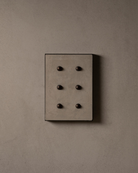 Surface-mounted MATA switch with six bullet-shaped button on a beige micro cement textured wall plaster – Sumum x Studio STRAF. Curated by Numa Home for the Netherlands and Türkiye Markets.
