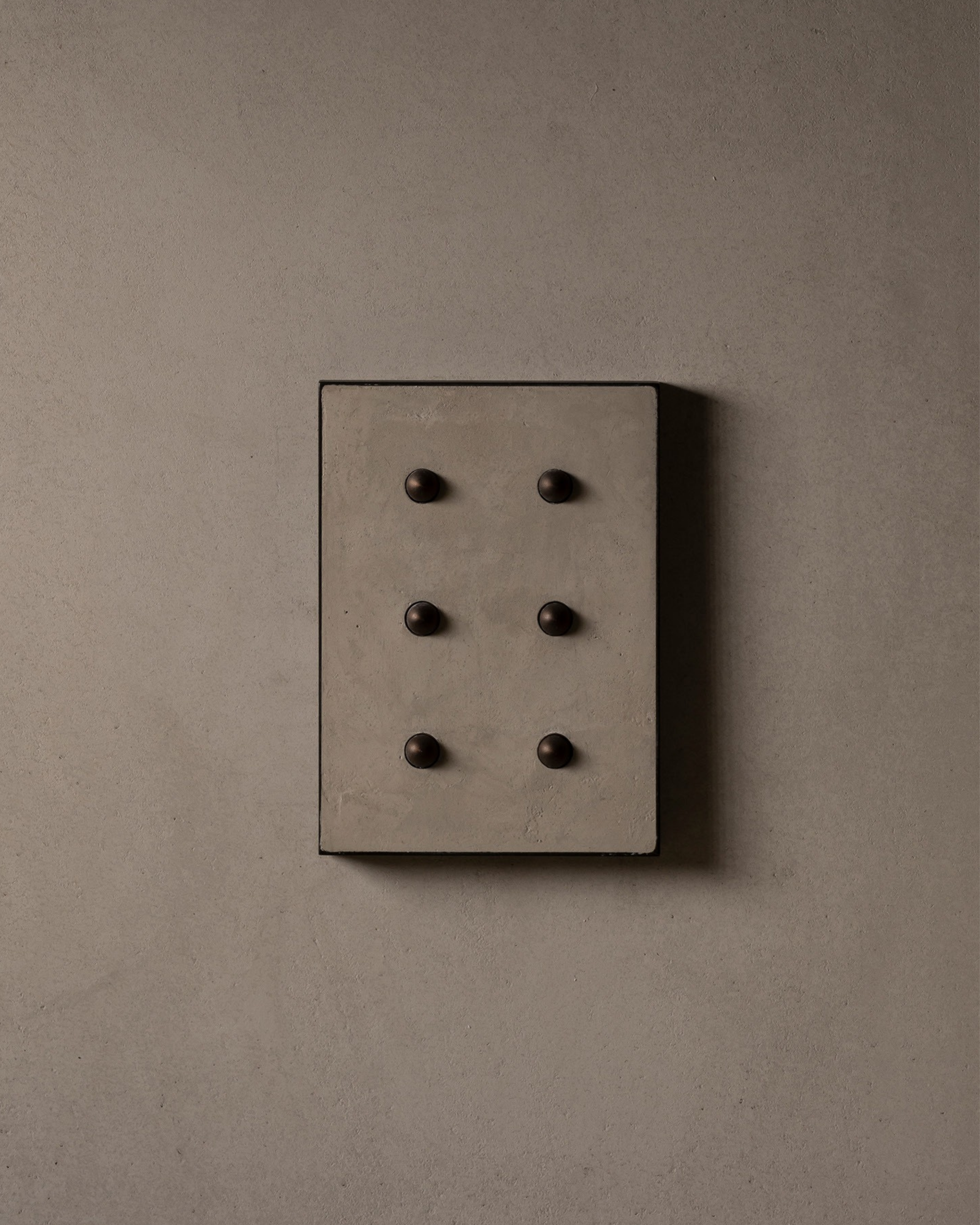 Surface-mounted MATA switch with six bullet-shaped button on a beige micro cement textured wall plaster – Sumum x Studio STRAF. Curated by Numa Home for the Netherlands and Türkiye Markets.