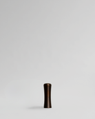 Brass handle on a light gray background. Brass cabinet handle designed by Stef Claes, created by Sumum, curated by Numa Home.