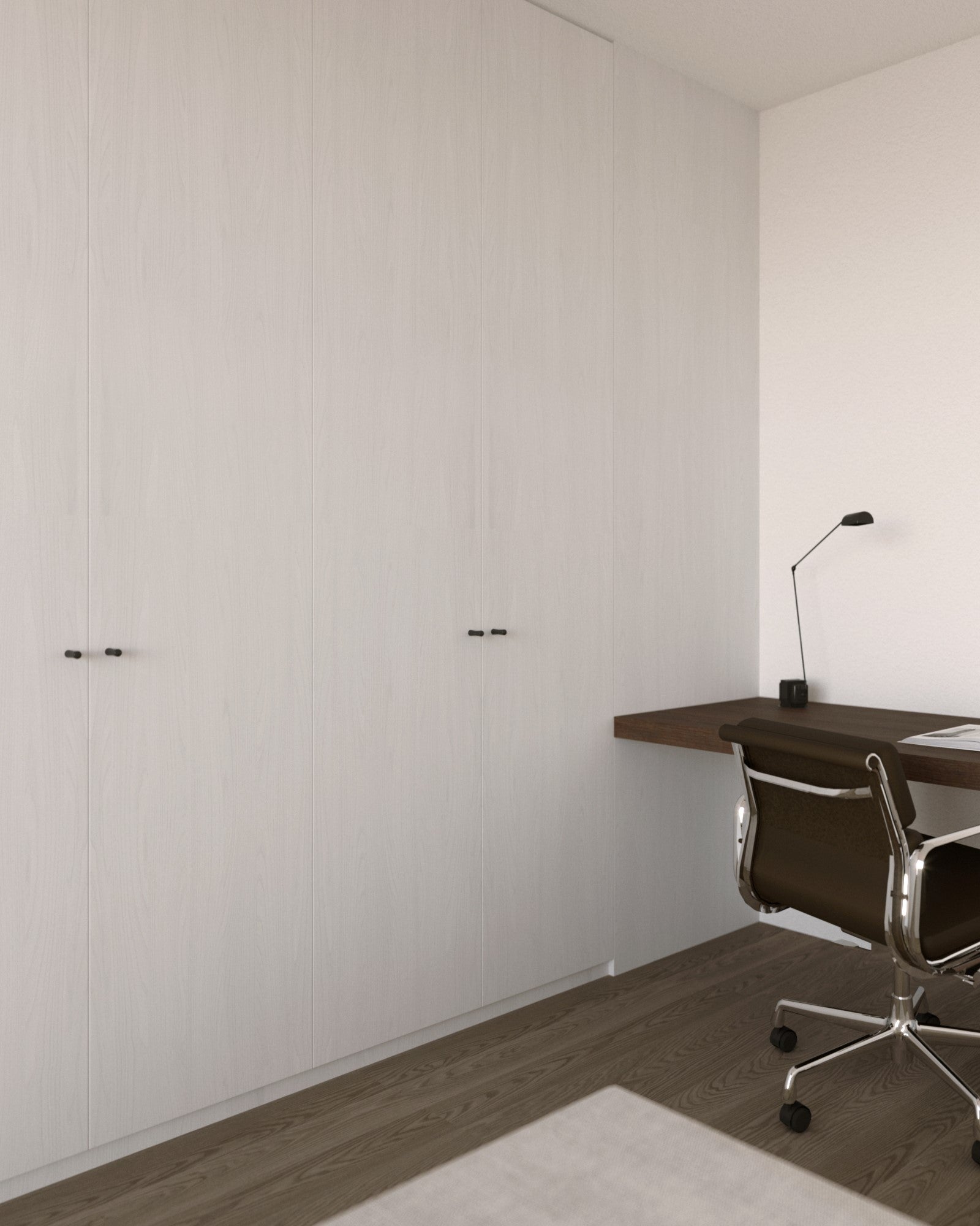 Minimalist home office with a wooden desk and chair against a white wall.