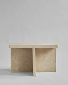 Beige stone like bench on a plain gray background. 101 Copenhagen curated by Numa Home