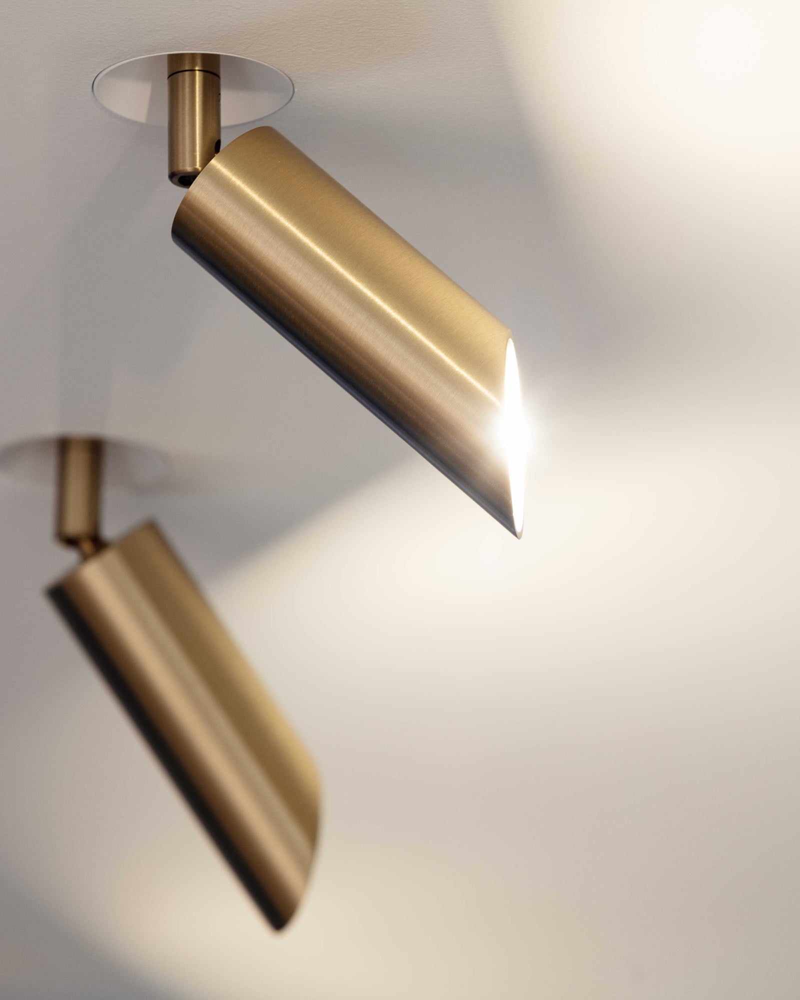 Brushed brass ceiling light fixture on a neutral background. Sumum brass spotlights made from brass partnered with PSM Lighting